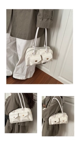 Detailansicht einer weißen Bowling-Schultertasche aus Leder mit zwei Metallverschluss-Taschen