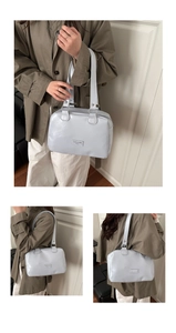 Détail du sac à main en cuir verni bleu clair avec logo et boucles métalliques