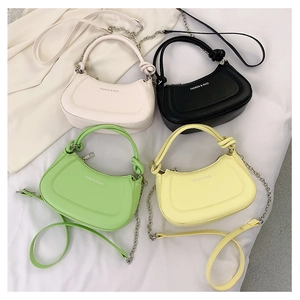 Detail of four colorful crossbody bags with knotted handles and metal chain straps