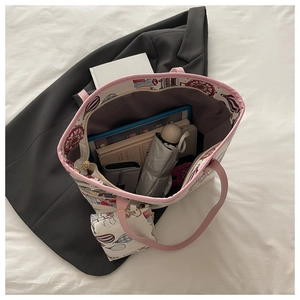 Detail view of pink cartoon tote bag showing large capacity for tablet, books, and umbrella