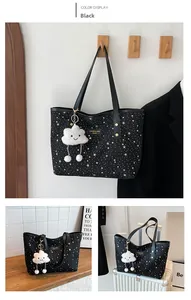 Détail du sac cabas à motif étoilé avec logo en cuir et accessoire de charme en peluche