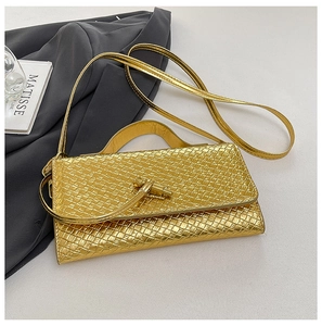 Detail of light gold woven texture and unique metal knot clasp on an elegant evening bag