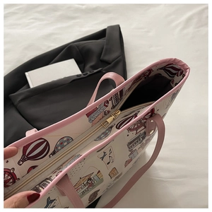 Top view of cartoon tote bag showing pink leather handles and gold zipper closure detail