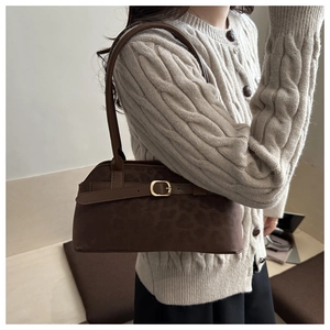 Close-up of a dark brown leopard print shoulder bag with a stylish golden square buckle