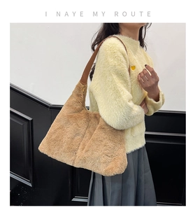 Dettaglio della borsa tote in ecopelliccia color cammello con manici in pelle marrone
