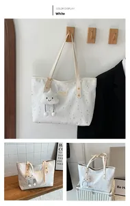 Détail du sac cabas blanc avec charm nuage et motif étoilé sur un crochet en bois