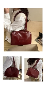 Sac Boston rouge foncé en cuir huilé avec poignées supérieures et logo en métal vintage
