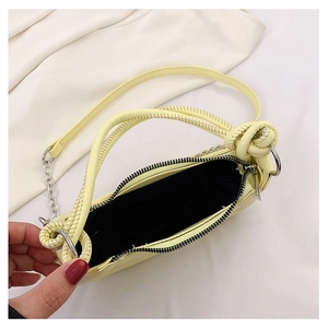 Top view of yellow leather bag showing black fabric interior and woven rope handle
