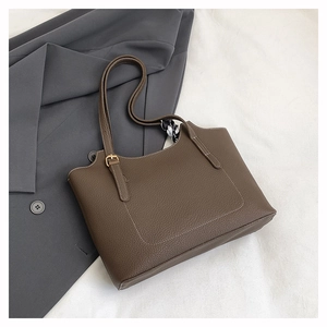 Detail of brown litchi leather tote bag with white stitching and silk scarf wrap