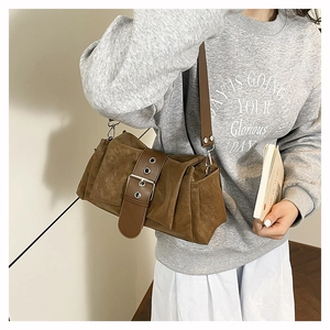 Détail du sac bandoulière en daim marron avec boucle en cuir et fermoir argenté