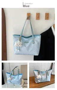 Détail d'un grand sac fourre-tout bleu clair avec étoiles argentées et charm nuage