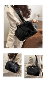 Détail d'un sac à main en cuir verni noir avec doubles anses et plaque de logo