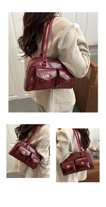 Detail der burgunderroten PU-Boston-Tasche mit mehreren Taschen und goldenem Drehverschluss