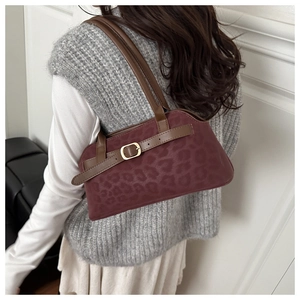 Close-up of leopard pattern suede tote with premium brown leather trim and gold buckle