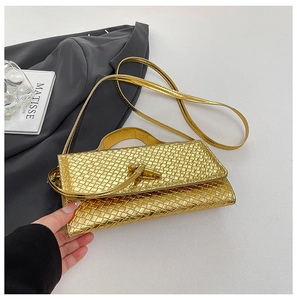 Detailed macro view of gold woven texture bag with metallic lock and slim strap
