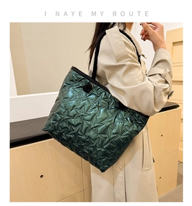 Gros plan du sac cabas matelassé vert foncé avec motifs d'étoiles et poignées tressées