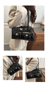 Detailansicht der schwarzen Boston Bag aus Lackleder mit goldenen Drehverschlüssen und Taschen