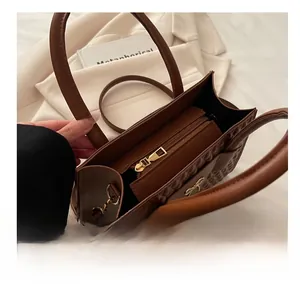 Detail view of brown tote bag interior featuring gold metal zipper and quilting