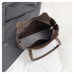 Top view of deep brown tote bag interior with litchi grain texture and gold zipper detail