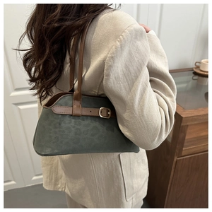 Detail of green suede shoulder bag with leopard print and brown leather trim