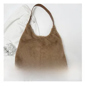 Borsa tote marrone in pelliccia sintetica con tracolla in pelle e smartphone per scala
