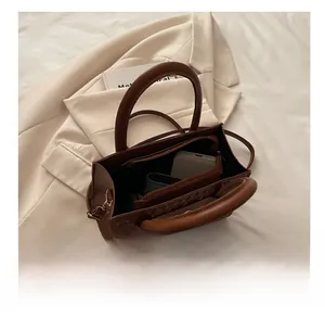 Top view of brown leather tote showing spacious interior compartments and zip pocket