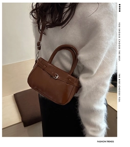 Détail d'un sac à main vintage en cuir brillant marron avec boucle de ceinture décor