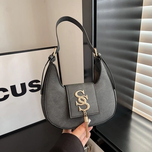 Black crescent shoulder bag with golden logo lettering and long metallic fringe tassels
