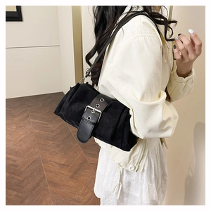 Détail du sac à bandoulière plissé noir avec de grands oeillets argentés et boucle métal