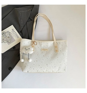 Détail d'un sac cabas en toile beige avec étoiles argentées et charm nuage doux