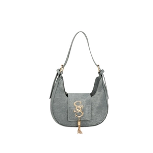 Chic grey hobo shoulder bag with golden S logo and decorative tassel on white background