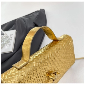 Macro shot of gold woven texture evening bag with distinctive metal knot clasp detail