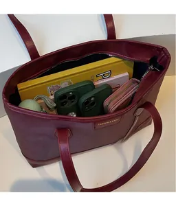 Deep red tote bag interior showing large capacity for books and a wallet with zipper