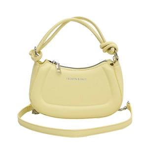 Detail of light yellow half moon bag with silver zipper and woven handle detail