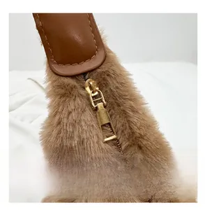 Dettaglio della cerniera dorata su borsa tote in peluche con bordo in pelle marrone