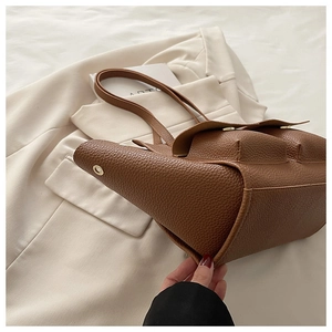 Detail of dark brown pebble leather tote bag with dual front pockets and gold hardware