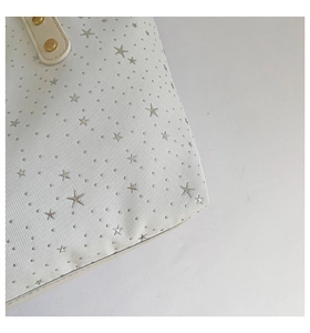Détail du sac cabas beige avec clous en métal argenté et texture en sergé chic