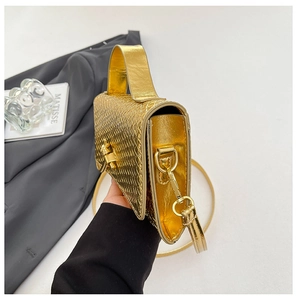 Close-up of golden woven texture and metallic lock on stylish crossbody evening bag