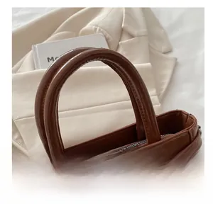 Détail du sac à main en cuir PU marron avec fermeture éclair et poignées rondes