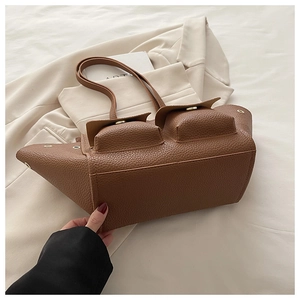Close-up of brown litchi pattern leather tote bag with two front flap pockets