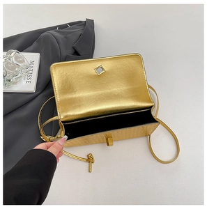 Macro view of champagne gold bag texture with metallic twist lock and black lining