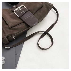 Détail d'un sac porté épaule vintage marron foncé avec cuir texturé et boucle argentée