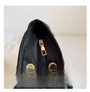 Détail de la fermeture éclair noire et du métal doré sur un grand sac cabas