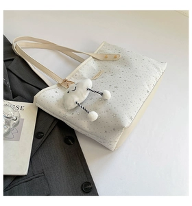 Détail du cabas blanc à imprimé étoiles avec un charmant pendentif nuage en peluche