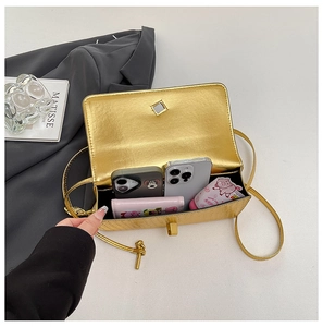 Interior view showing the capacity of a metallic gold crossbody bag with everyday items