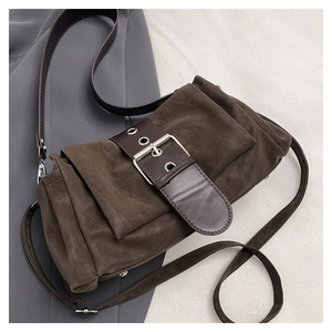 Détail d'un sac bandoulière plissé marron foncé en cuir mat avec boucle de style vintage