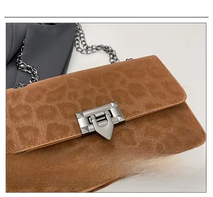 Detail of silver matte metal lock on leopard print faux suede brown chain bag
