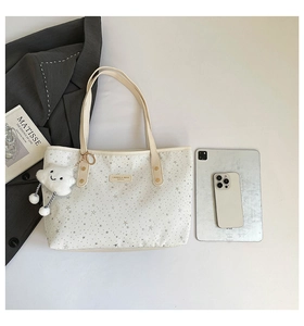 Vue détaillée du sac cabas blanc à motif d'étoiles avec charm nuage et ordinateur
