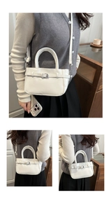 Détail d'un sac bandoulière blanc avec boucle argentée et fine bandoulière amovible