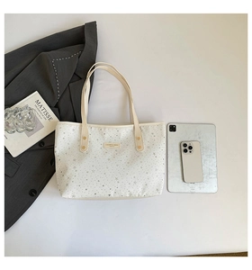 Détail du sac cabas en toile blanche avec étoiles argentées et rivets dorés renforcés